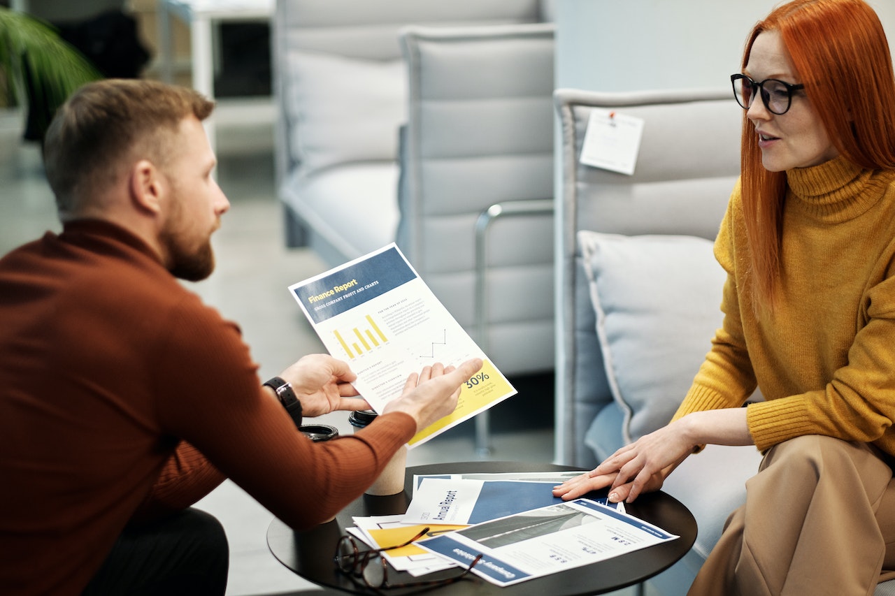 Man Showing Red Hair Woman A Graph